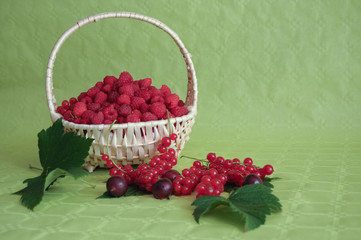 Braided basket of strawberries and red currant in foreground