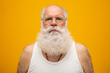 Old man with a long beard on a yellow background. Senior with full white beard. Old man with a long beard with sadness. - Powered by Adobe