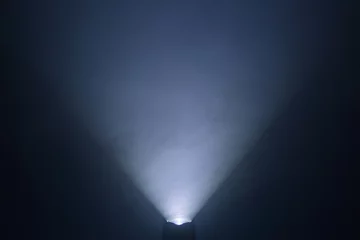 Foto op Plexiglas zaklamp en lichtstraal in donkere mistkamer & 39 s nachts. abstracte projector spotlight wit lag aan het groeien. © Rattanachai