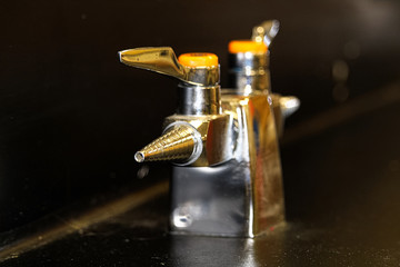 A lab gas valve on a black table and background