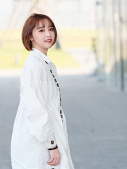 Beautiful young brunette woman in white shirt smiling at camera in sunny day. Outdoor fashion portrait of glamour Chinese cheerful stylish girl, emotions, people, beauty and lifestyle concept.