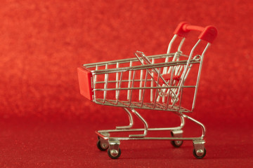 Supermarket trolley on defocused red background