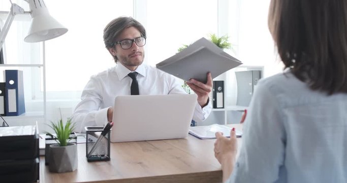 Young manager rejecting a job application of female candidate at office