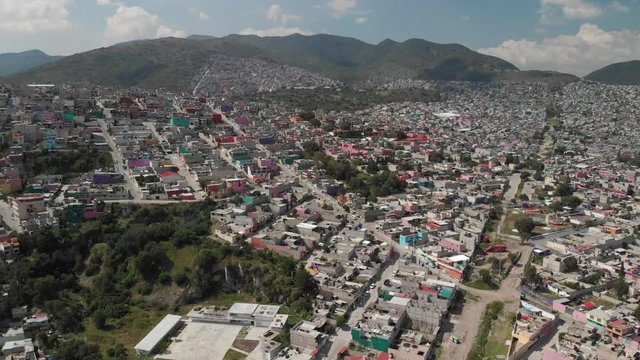 Aerial in colorful Ecatepec, Mexico. Drone flying bacwards over the houses