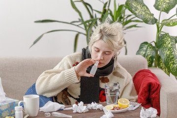 The girl in the sweater is sick lying on the couch. Colds and flu. The patient caught a cold,...