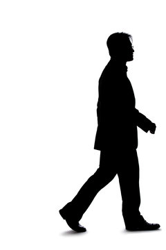 Full body silhouette of a businessman isolated on a white background. He is in a walking gesture and moving by taking a step forward