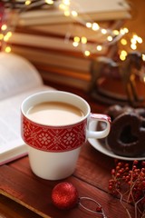 Winter tea. Winter books.  cup of  tea, books, Christmas gingerbread cookies, decor and a shining garland on a red wooden background.Books about Christmas. Winter holidays.