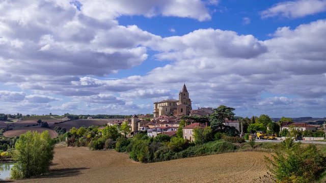 timelapse of the french village of Lavardens in the Gers with blue sky and white clouds