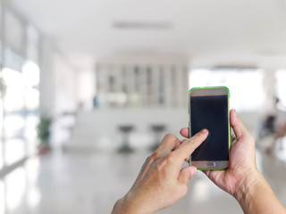 hand holding mobile smart phone with register counter blurry background