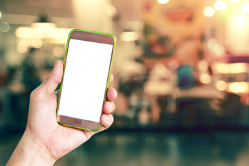 hand holding mobile smart phone with restaurant blur background,vintage effect style
