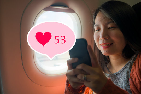 Asian girl sharing travel experience on social media . young happy beautiful Korean tourist woman in airplane cabin getting internet likes online posting her holiday trip - Powered by Adobe