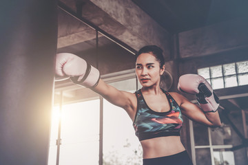 Fototapeta na wymiar Woman workout with punching bag in sports gym