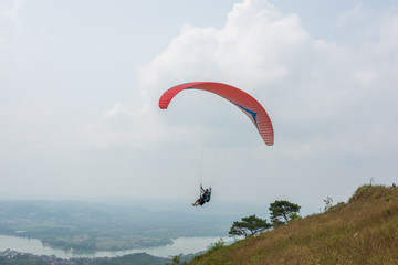 Red paraglider just taking off on the top of the mountain