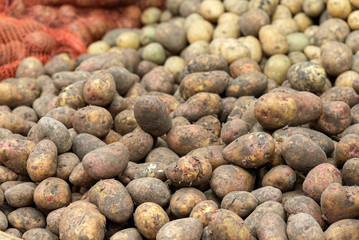 A pile of potatoes on a market counter.