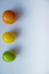 Red, yellow, green tomato on a white background. copy space, top view, flat lay, background with blank space for text