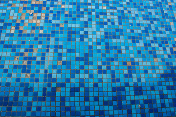 Blue and blue tiled mosaic at the bottom of the pool without water.