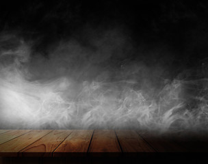 Wooden table with smoke and black backgrounds