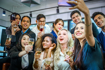A group of business people holding a glass of champagne in a party to celebrate their success