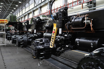 Heavy wheeled tractor on assembly line of the plant for transport non-standard cargo unusual background