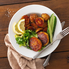 Plate of food. Fresh vegetarian cutlets with new potatoes and salad on a wooden table top view