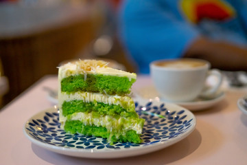 A slice of chocolate cake on the plate. Gula Melaka cake in green colour. Coffee cake tea time concept.