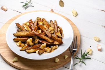 Montreal Poutine gravy fries dish. A classic fast food cuisine dish from Quebec. This canadian comfort food is made with french fries mixed with tasty cheese curds and a delicious brown gravy sauce.