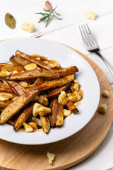 Poutine vertical portrait view. This canadian comfort food is made with french fries mixed with tasty cheese curds and a delicious brown gravy sauce.