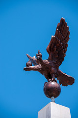 Russia, Khabarovsk, June 22, 2019: Copper double-headed eagle on blue sky background, sculpture, top on Stella