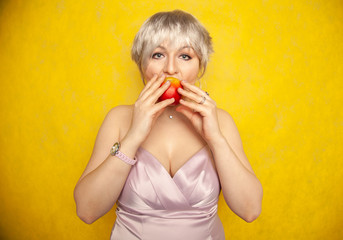 Close up pretty young woman holding an apple she's about to eat