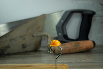 Carpentry nail shaped as question mark and helmet