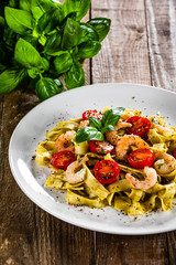Shrimps with pasta tagliatelle with spinach and tomatoes