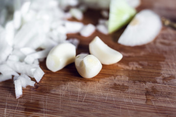 Garlic cloves and sliced onion on cutting board