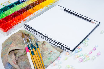 closeup open note book with tray colors on background