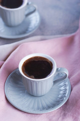 Black coffee in a small mug with a saucer