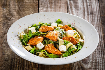 Pasta with chicken meat, feta cheese and rucola