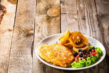 Fried pork chop, onion rings and vegetables
