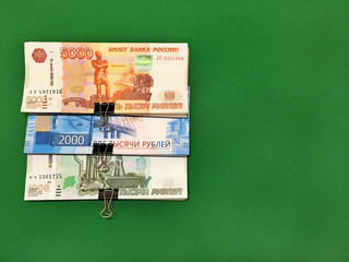 Money rubles pack on a green isolated background. Russian banknotes one thousand, five thousand, two thousand