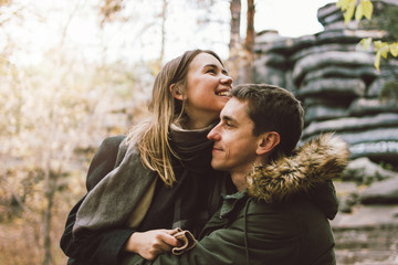 Happy young couple in love friends dressed in casual style walking together on nature park forest...