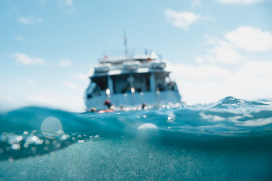 Great barrier reef, Australia: Cruise boat in the middle of the ocean, underwater photo, half/half