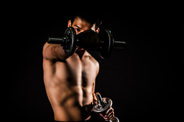 Fototapeta na wymiar sport man standing doing exercise for arms with dumbbells and showing muscle bodybuilding on black backgrounds, fitness concept, sport concept