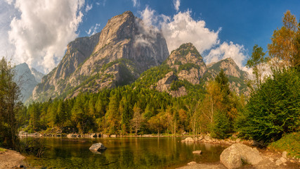 mountain lake in the valley with forest and mountain peaks in the background