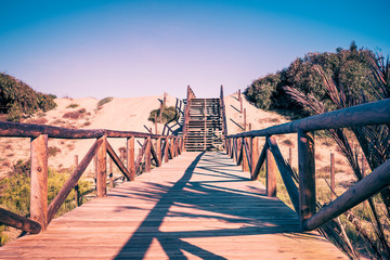 Obraz premium arid landscape with wooden path and stairs ascending towards the sky