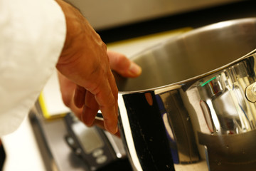 professional cook in kitchen preparing food for customers showing hands and utilities