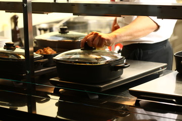 professional cook in kitchen preparing food for customers showing hands and utilities