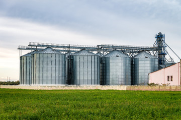 Fototapeta na wymiar agro-processing and manufacturing plant for processing and silver silos for drying cleaning and storage of agricultural products, flour, cereals and grain. Granary elevator