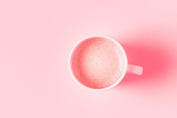 Cup of coffee on a pink pastel background.