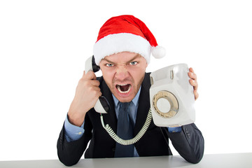 Nervous angry businessman in santa claus hat screaming on a telephone isolated on white background - Powered by Adobe