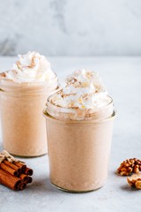 Pumpkin and carrot spice latte with whipped cream and cinnamon in glass jars