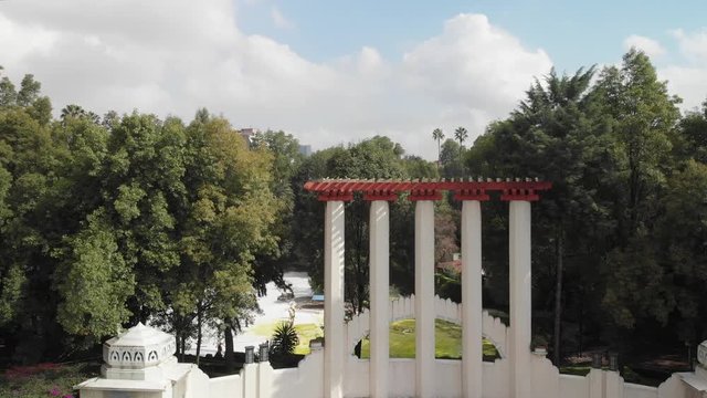 Drone slowly ascending from Parque Mexico revealing the surrounding skyline of Colonia Condesa