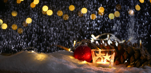 christmas theme with candles, snow, .pinecone and christmas light with pokeh effect